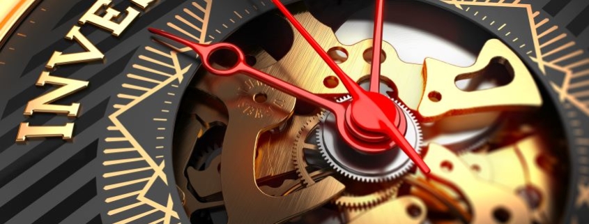 Image d'une montre avec le mot "Investment", symbolisant l'importance du timing dans la stratégie d'investissement patrimonial.