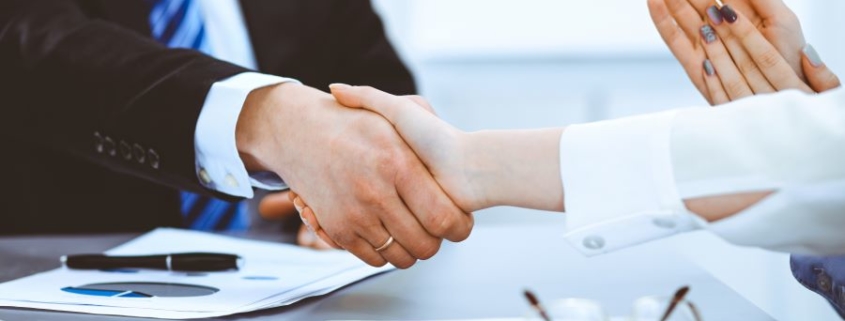 Conseiller et client scellant un accord, symbolisant une relation de confiance pour une stratégie patrimoniale sur mesure.