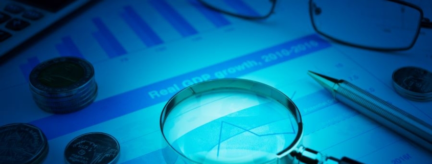 Loupe sur des documents financiers, symbolisant une analyse approfondie des investissements et de la fiscalité transfrontalière.