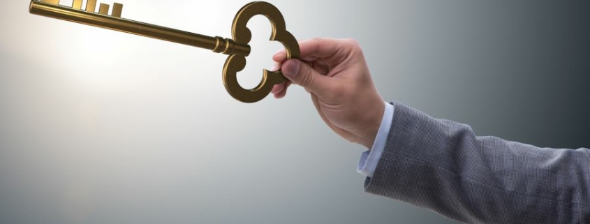 Main tenant une clé dorée, symbolisant l'accès à une stratégie patrimoniale sur mesure pour optimiser vos actifs.